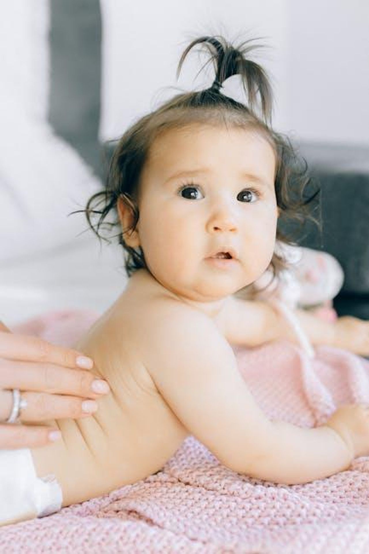 Source: Nataliya Vaitkevich - pexels - Cute baby lying on a pink blanket while receiving a soothing massage indoors, capturing tender moments.