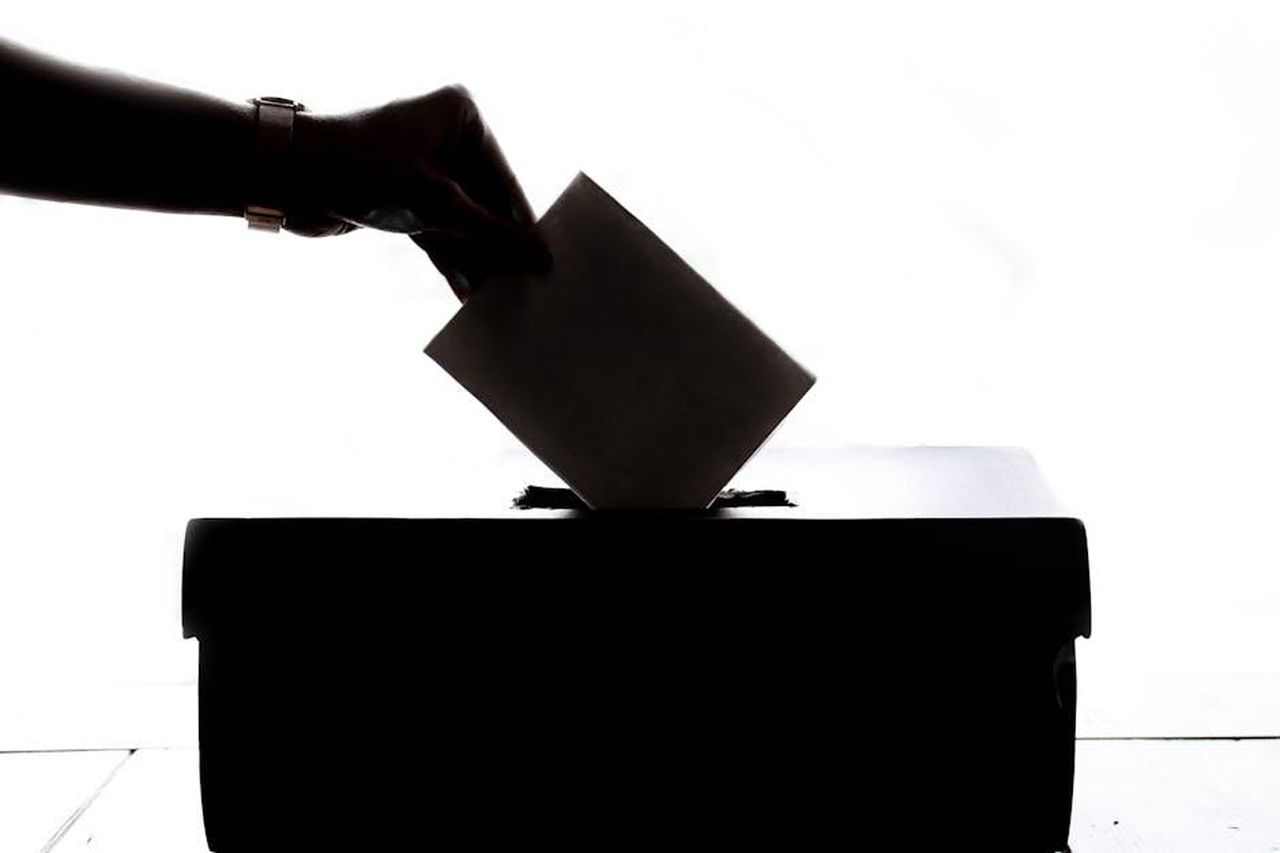 Source: Element5 Digital - pexels - Silhouette of a hand placing a vote into a ballot box, symbolizing democracy.