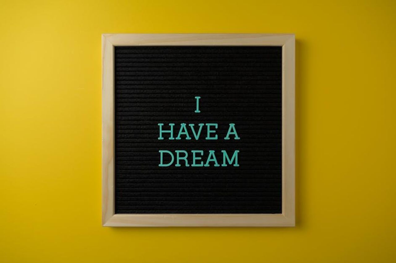 Source: Brett Sayles - pexels - Close-up view of a letter board with 'I Have a Dream' message on a vibrant yellow background.