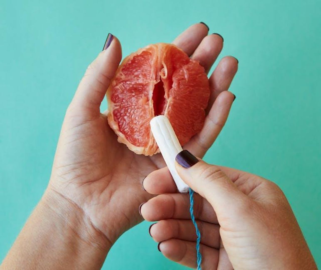 Source: Laker - pexels - From above of crop anonymous female demonstrating on sliced ripe grapefruit correct use of tampon against blue background