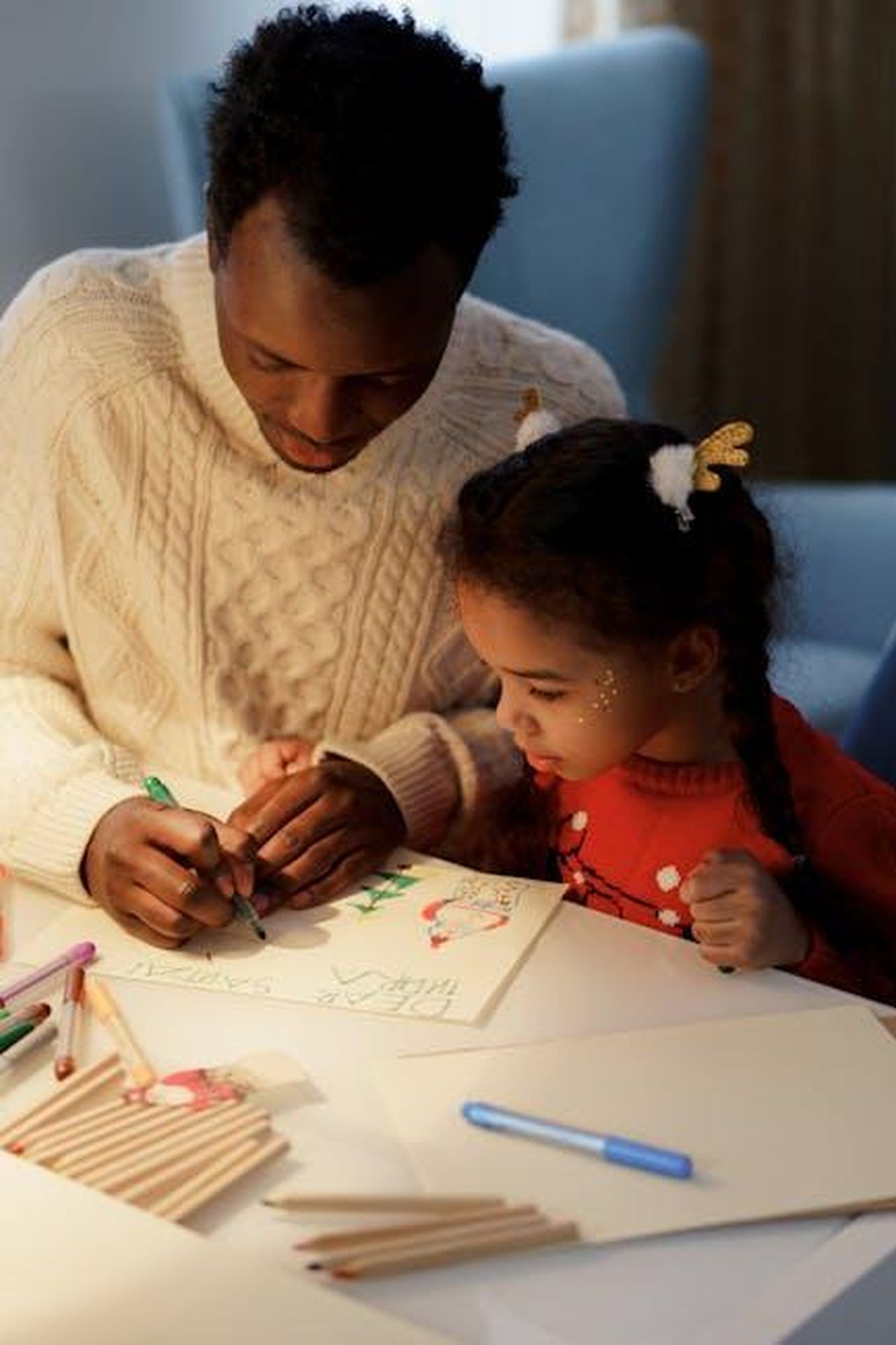 Source: cottonbro studio - pexels - Father and daughter enjoying quality time crafting a Christmas letter with colorful materials.