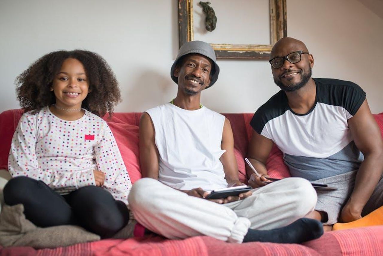 Source: Kampus Production - pexels - Smiling family sitting together on a couch, showing love and bonding at home.