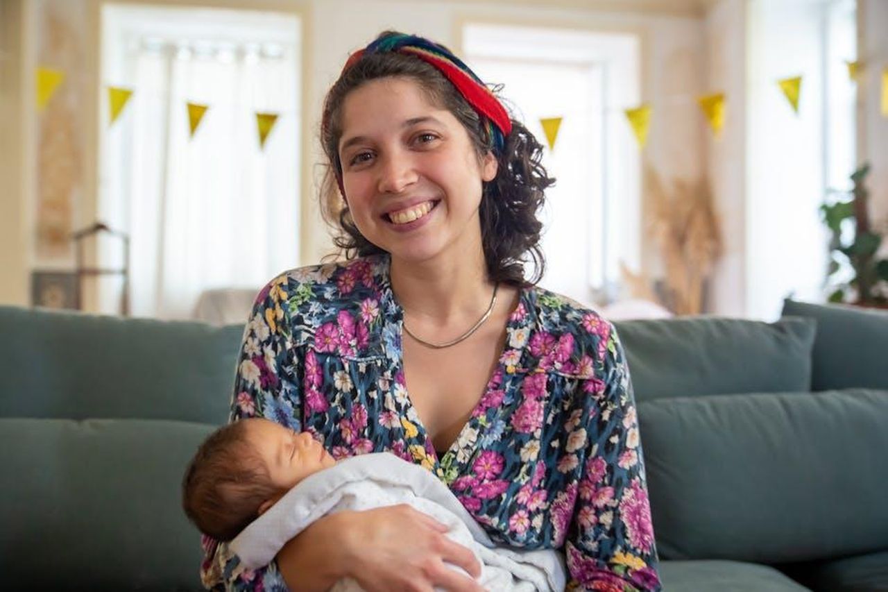 Source: Kampus Production - pexels - A joyful mother holding her newborn baby, wrapped in a soft blanket, at home in Portugal.