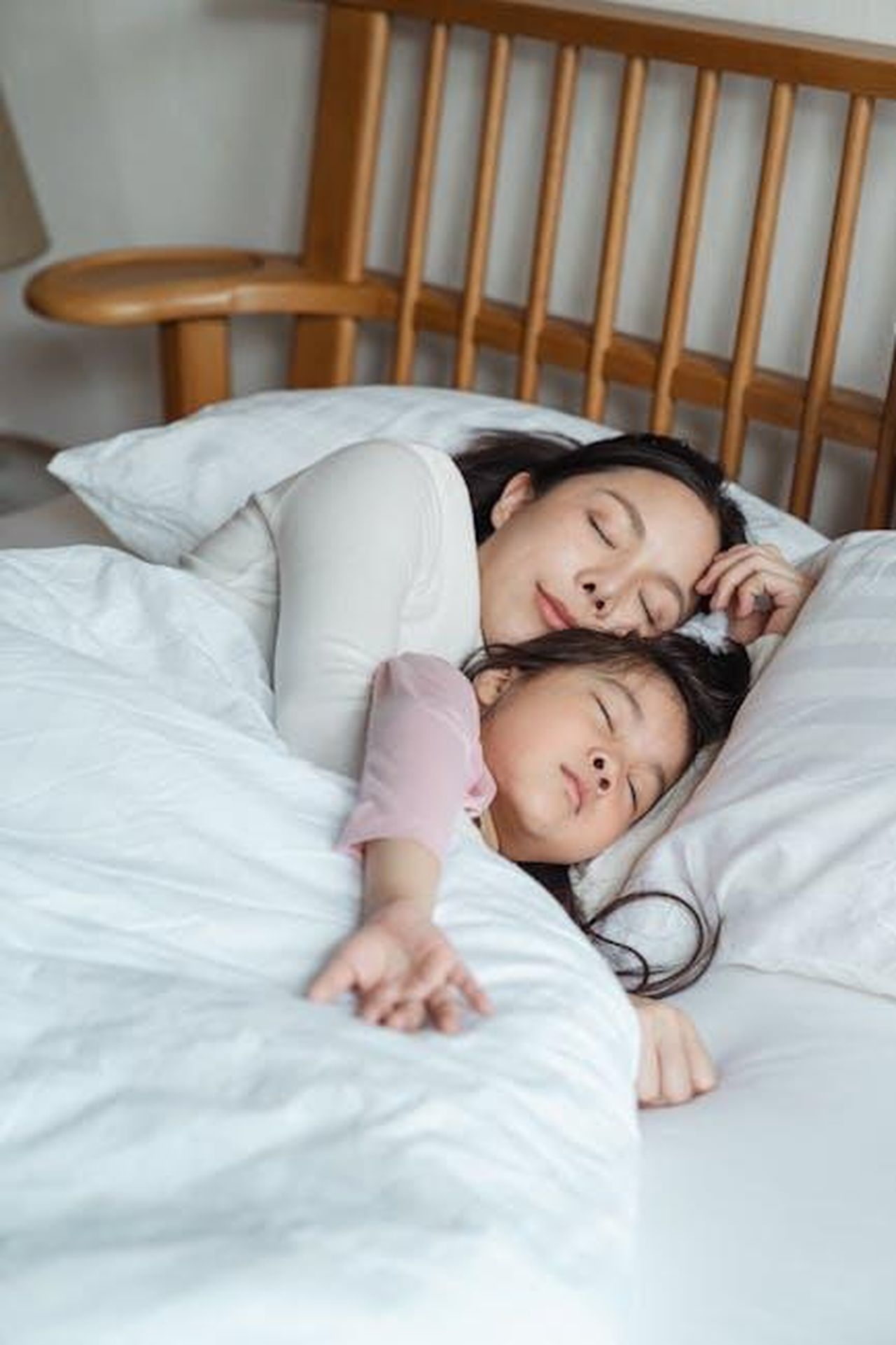 Source: Ketut Subiyanto - pexels - A serene moment capturing a mother and daughter cuddling in bed, enjoying restful sleep.