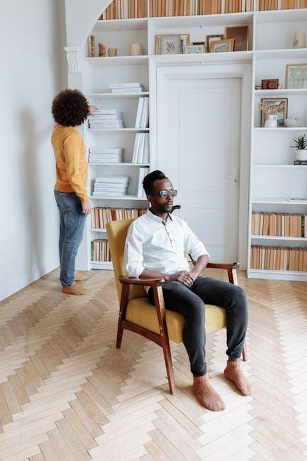 Source: Thirdman - pexels - Blind man sitting in a chair reading Braille in a modern library with stylish bookshelves.