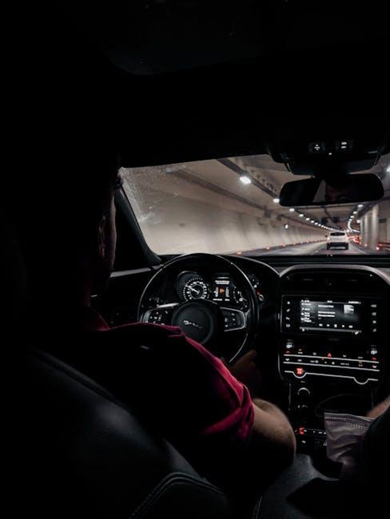 Source: ENESFİLM - pexels - Interior view of a car driving through a tunnel at night with dashboard lights visible.
