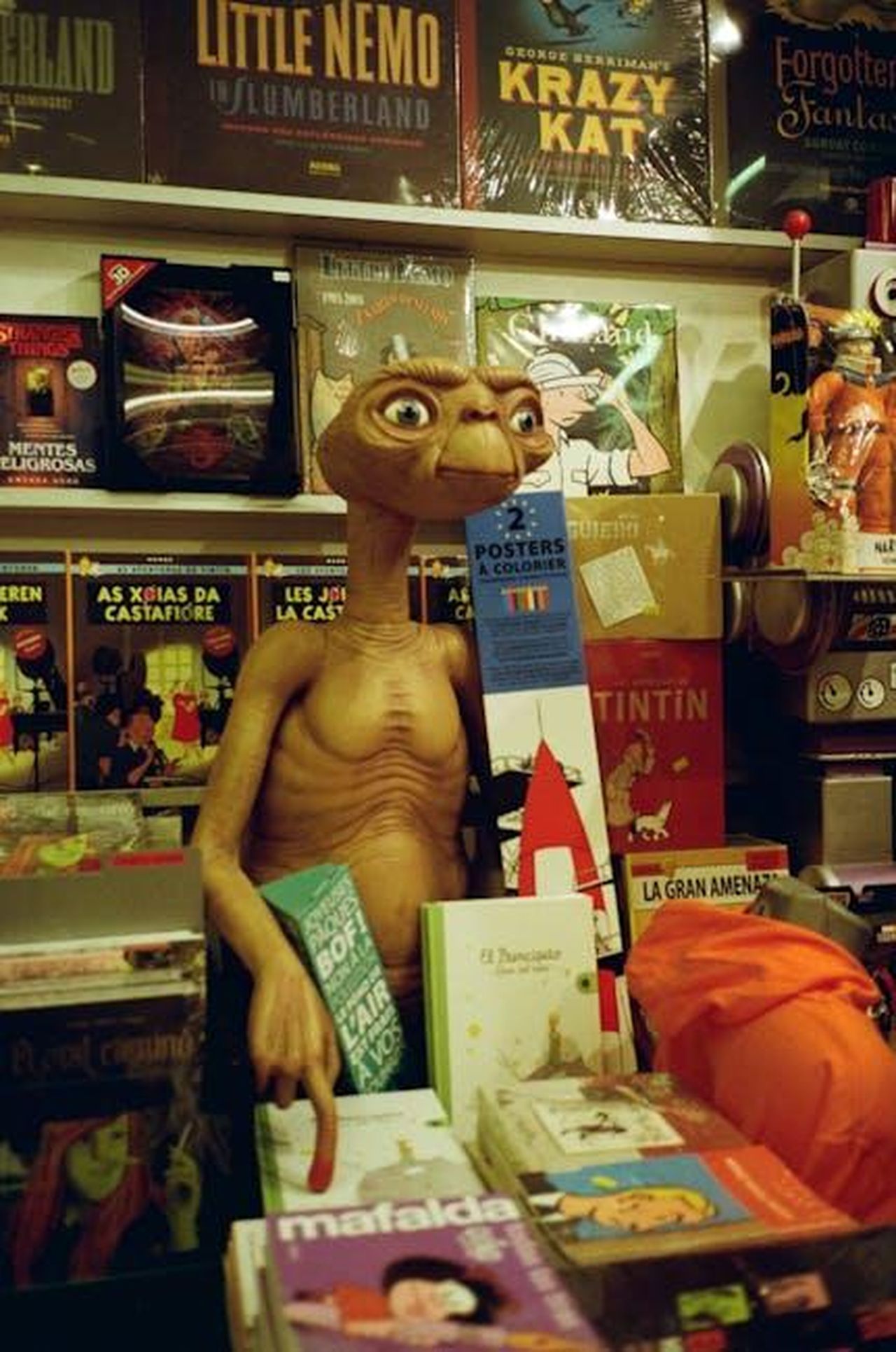Source: Liza Bakay - pexels - E.T. figurine displayed in a vibrant Barcelona bookstore surrounded by comic books.