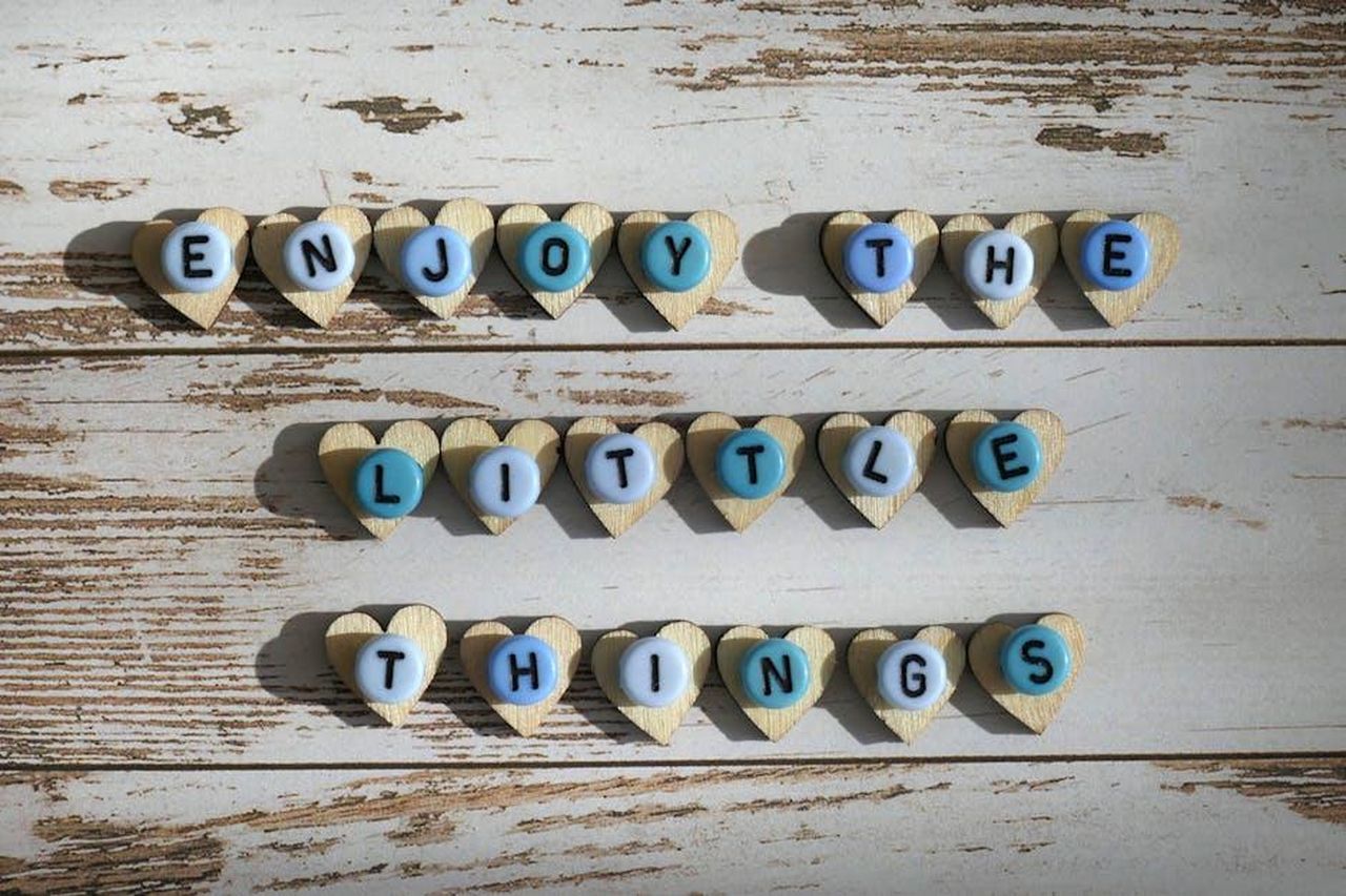 Source: Michaela St - pexels - Heart-shaped letters spelling 'Enjoy the Little Things' on a rustic wooden background for inspirational decor.
