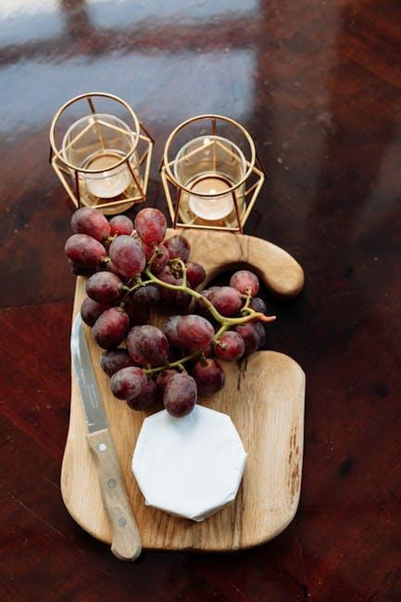 Source: Thirdman - pexels - A top-view still life of grapes and cheese on a wooden board, exuding rustic elegance.