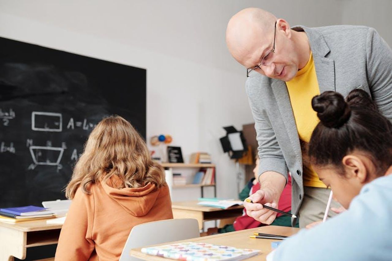 Source: Max Fischer - pexels - Teacher helping students in classroom, enhancing learning with personalized attention.
