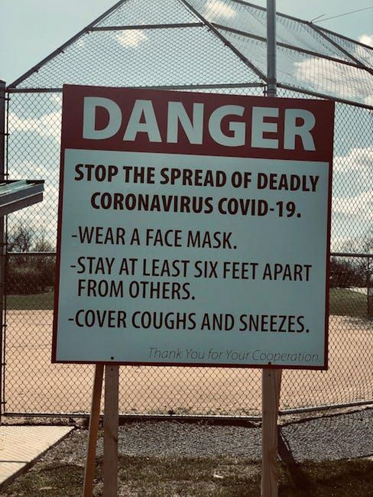 Source: Key Notez - pexels - Signboard advising COVID-19 precautions in a park, featuring social distancing and mask-wearing guidelines.