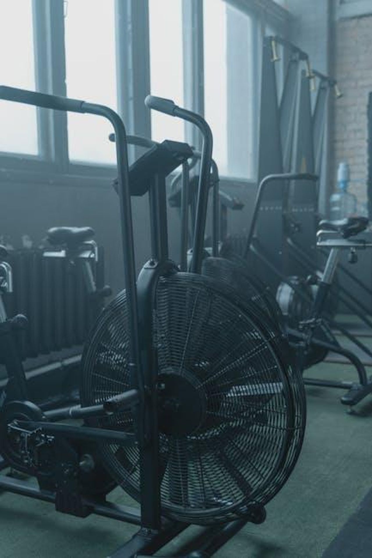 Source: Tima Miroshnichenko - pexels - A set of modern exercise bikes in a spacious gym with natural light and minimalist design.