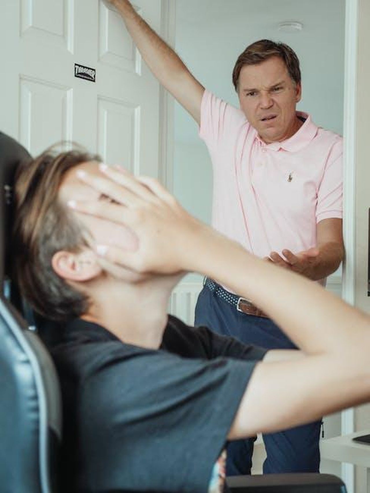 Source: Kindel Media - pexels - A father expresses anger while his son covers his face, illustrating a family argument.
