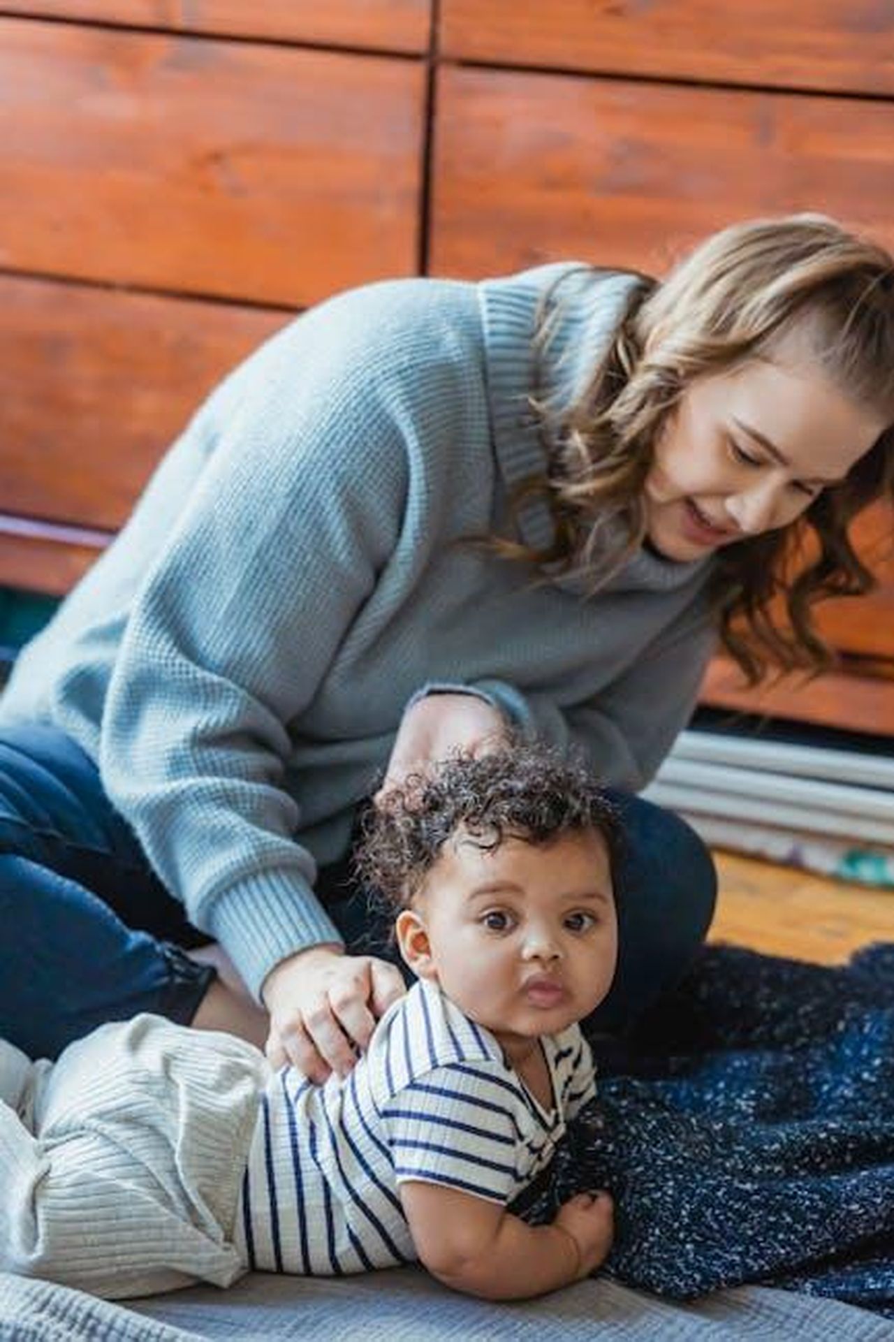 Source: Keira Burton - pexels - A loving mother cares for her curious baby indoors, capturing a tender moment of motherhood.