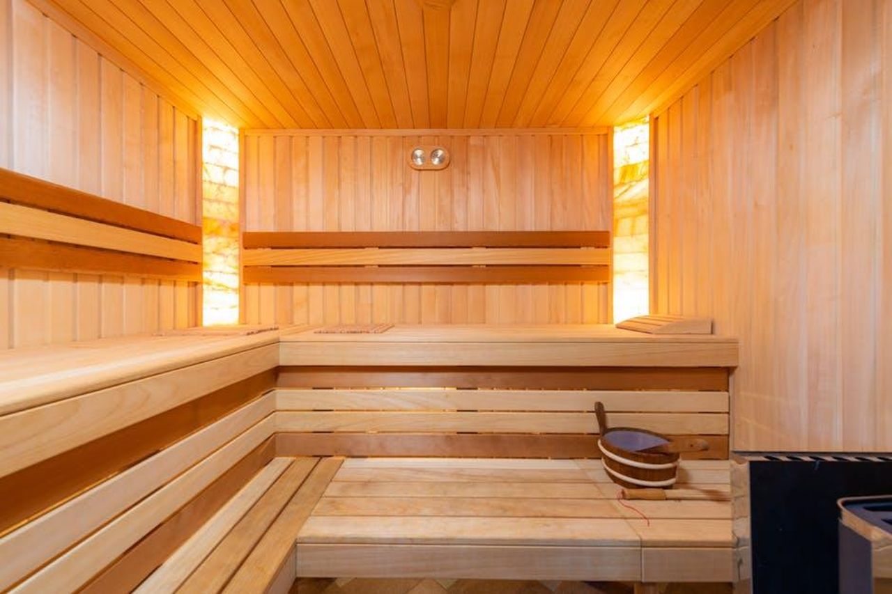 Source: Max Vakhtbovycn - pexels - Warm indoor sauna featuring wooden benches and relaxing ambiance.
