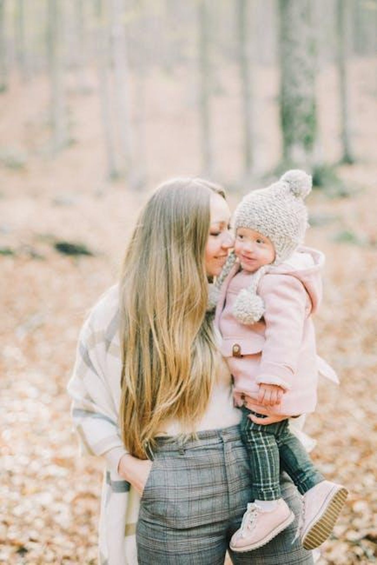 Source: Leeloo The First - pexels - A mom holds her daughter lovingly in a serene outdoor autumn setting, showcasing warmth and family bonds.