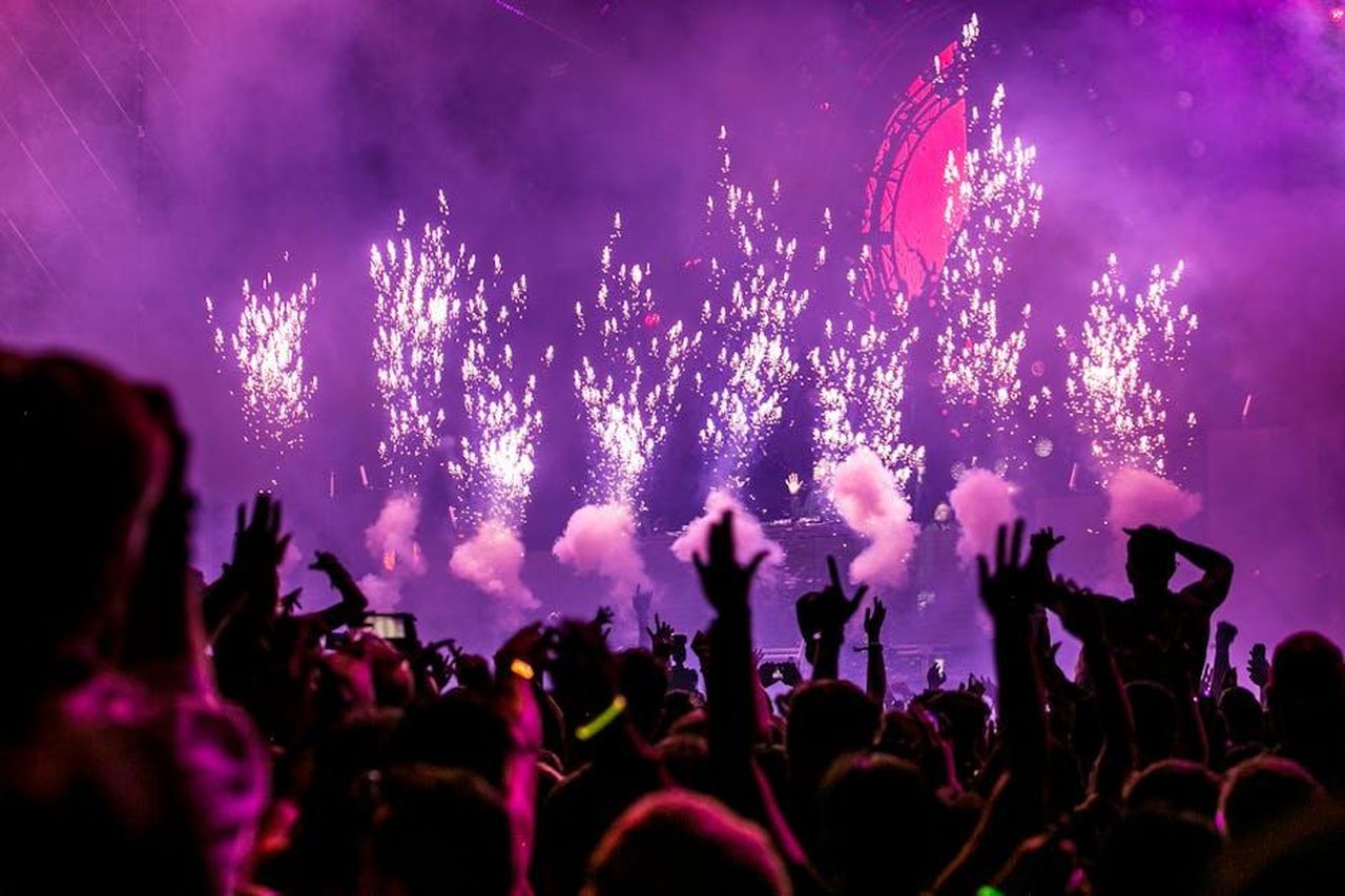 Source: Wendy Wei - pexels - Vibrant EDM concert scene with fireworks, smoke, and enthusiastic crowd enjoying the music.