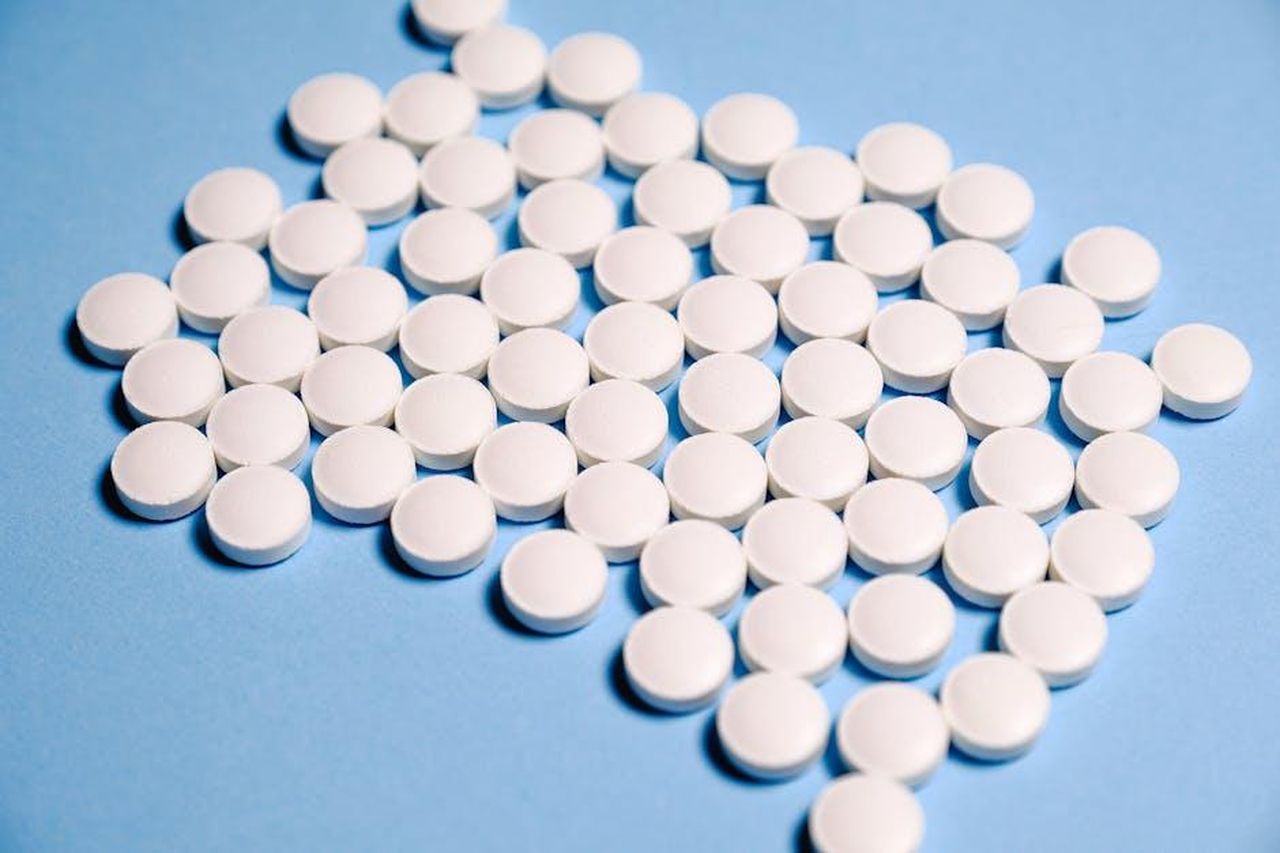 Source: Anna Shvets - pexels - Close-up of white pills on a blue surface representing healthcare and medication.