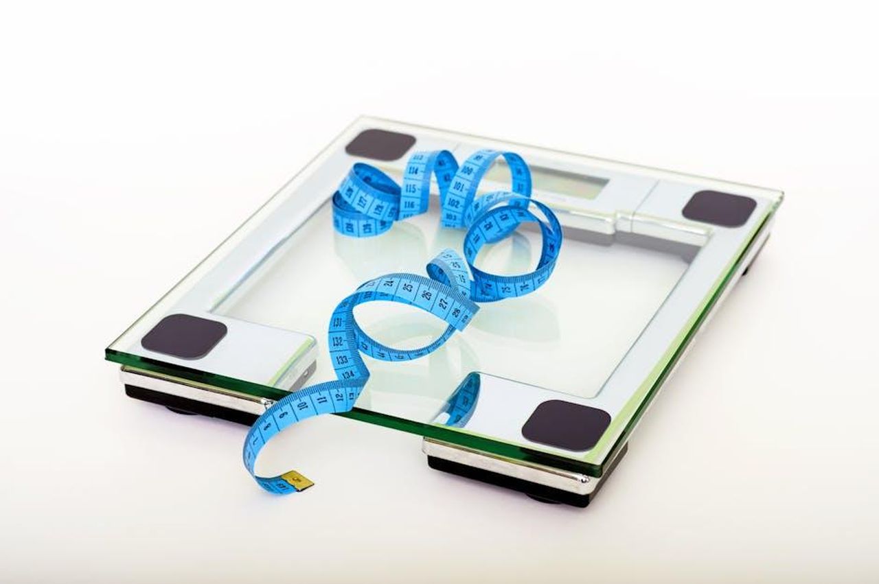 Source: Pixabay - pexels - A digital glass weighing scale with a blue measuring tape, symbolizing weight management.