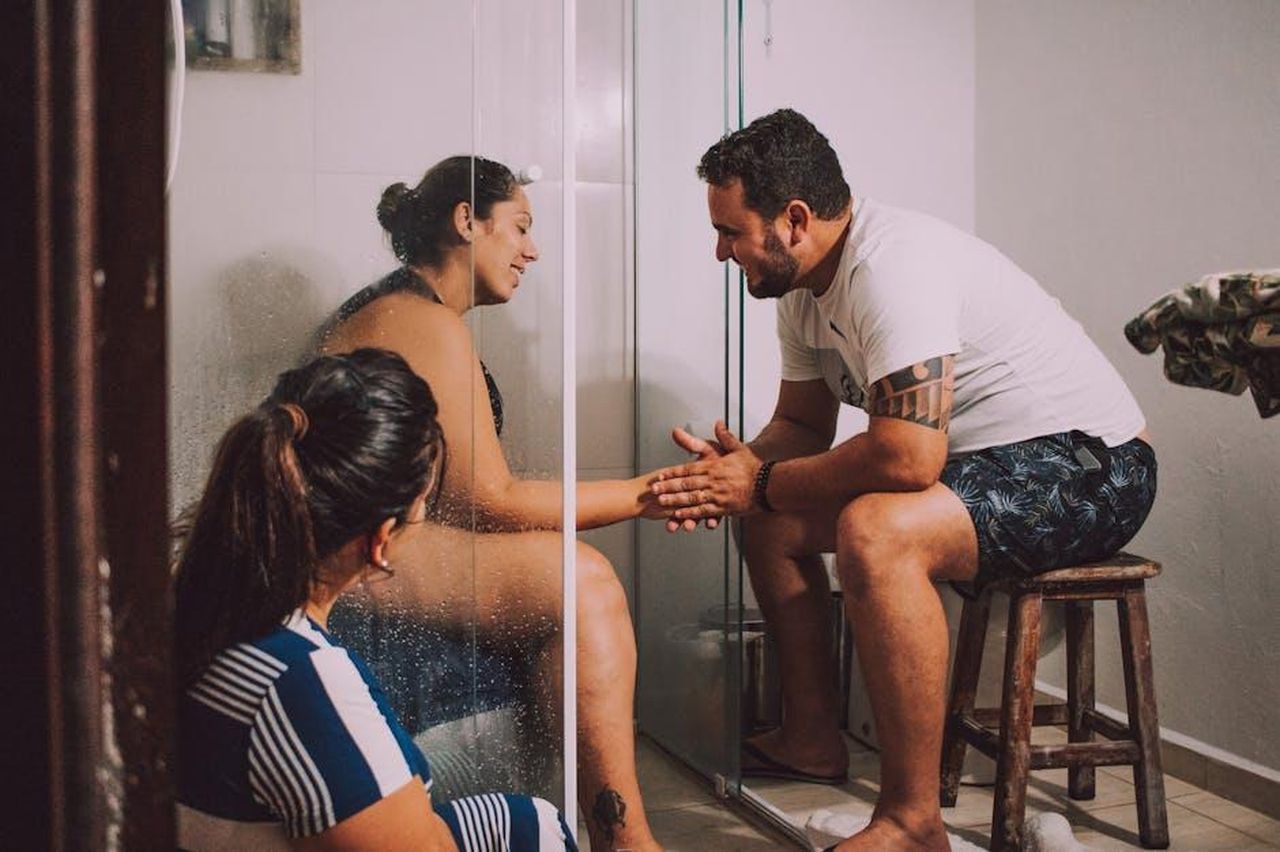 Source: Duda Oliveira - pexels - Intimate moment of support during labor. Warm and heartfelt interaction in a modern bathroom setting.