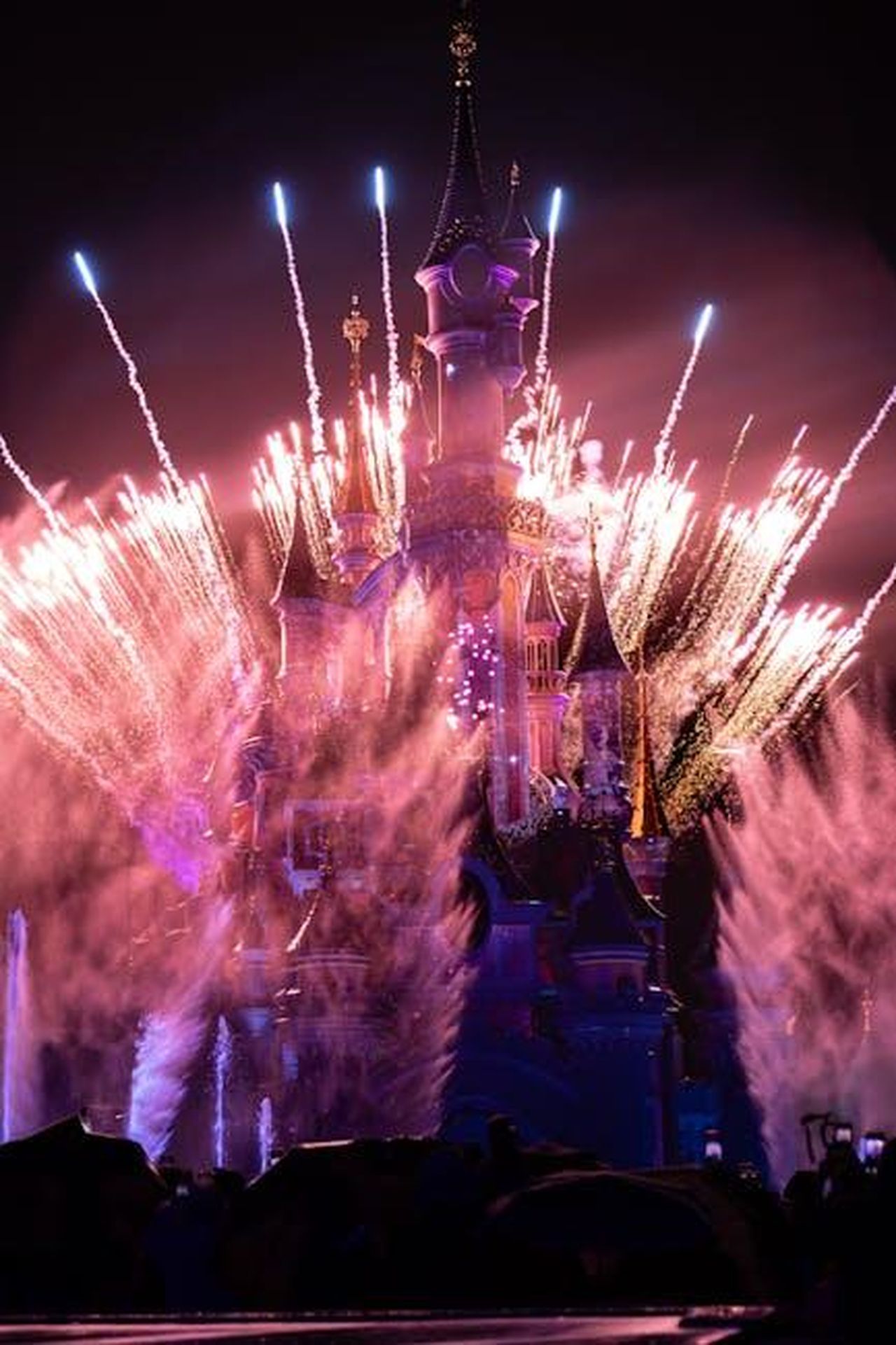 Source: Magalie Parise - pexels - A breathtaking display of fireworks lighting up the night sky over a fairy tale castle, capturing a magical and vibrant atmosphere.