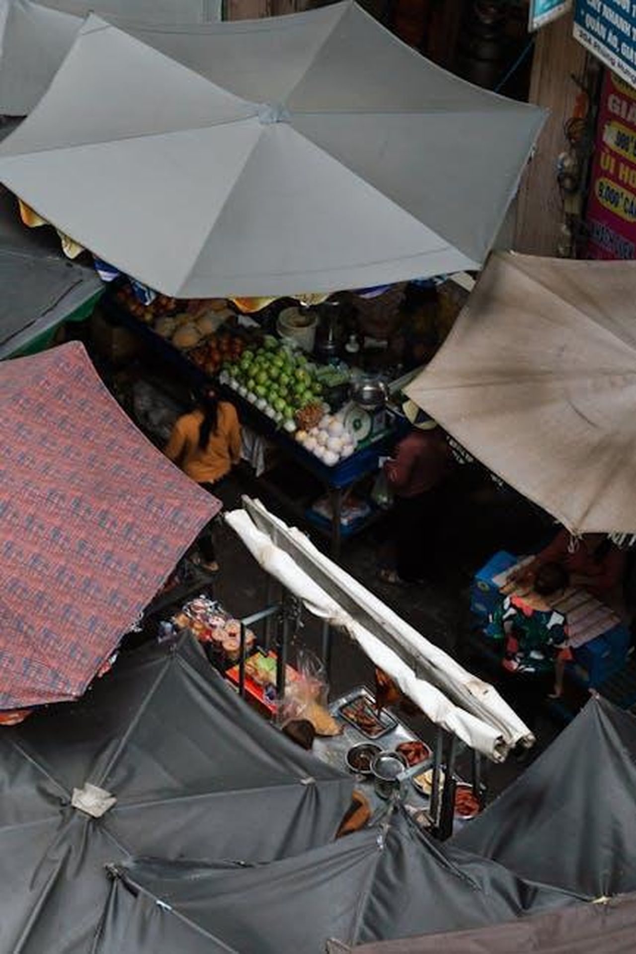Source: Thien Phuoc Phuong - pexels - Aerial shot of a vibrant outdoor market with food stalls and umbrellas, capturing daily life.