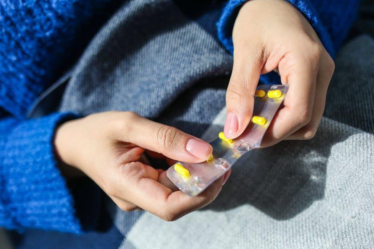 Source: Polina Tankilevitch - pexels - Close-up of a woman's hands holding a blister pack with yellow pills, indoors.