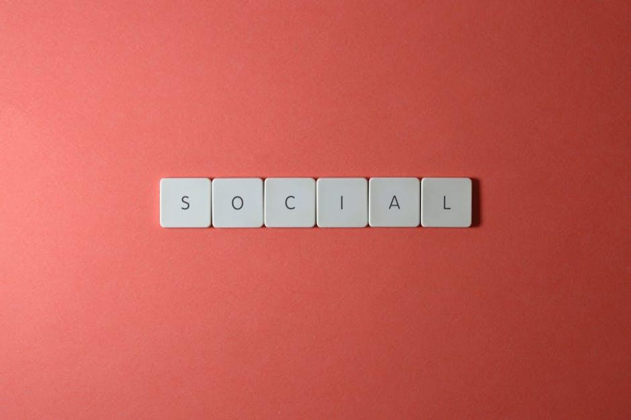 Source: Miguel Á. Padriñán - pexels - Close-up of the word 'SOCIAL' formed with tiles on a red surface, offering copyspace.