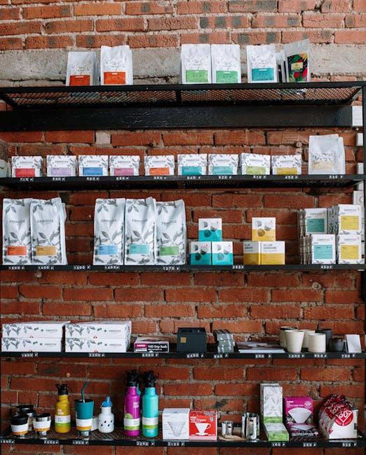 Source: cottonbro studio - pexels - Brick wall shelving in a café with various coffee products and modern decor.