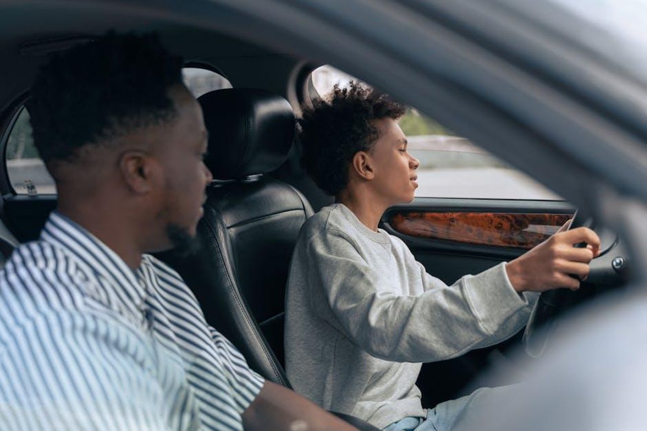 Source: Ron Lach - pexels - A father teaches his son to drive, sitting together in a car and discussing techniques. Side view indoors.