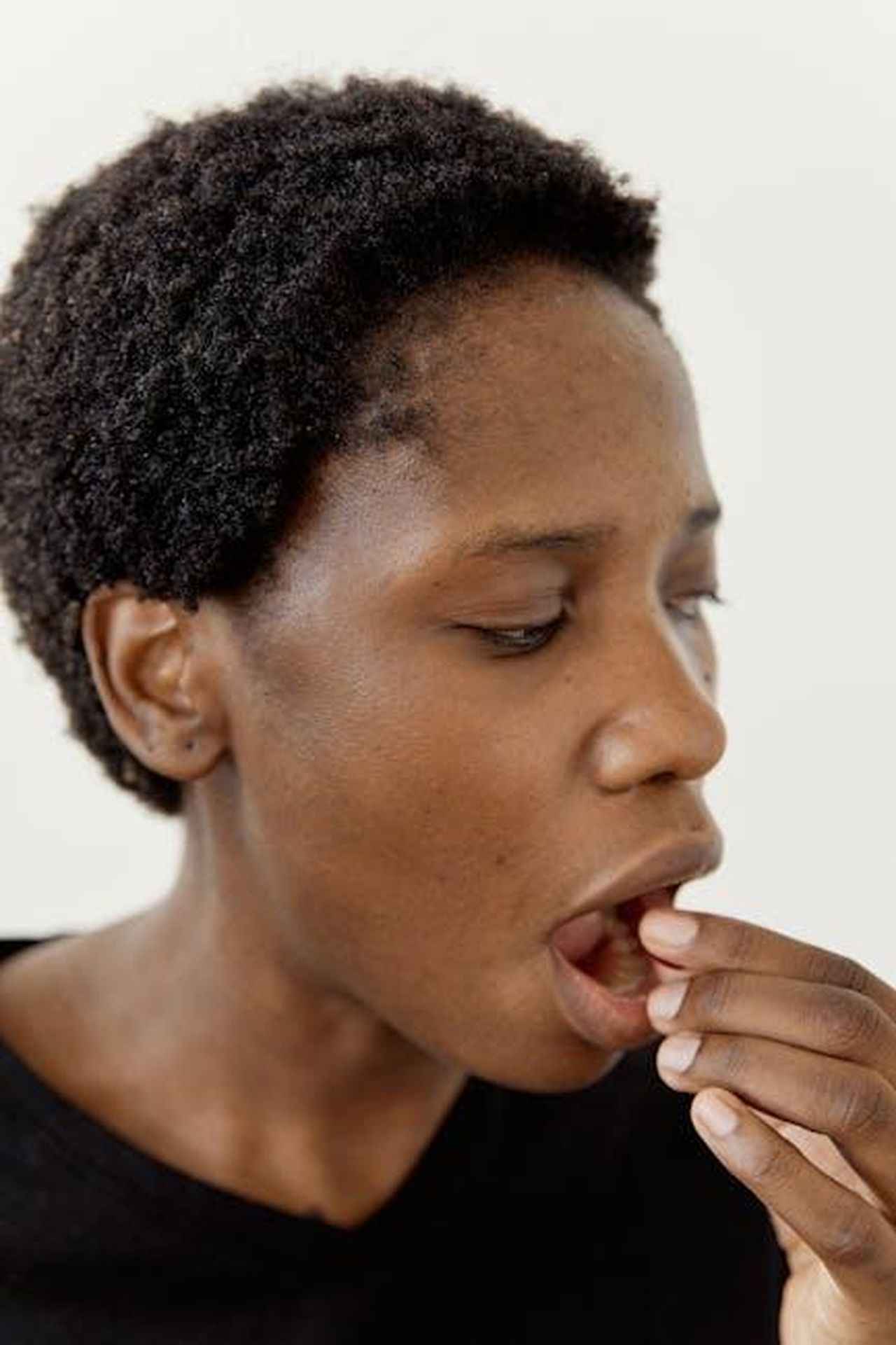 Source: Darina Belonogova - pexels - Adult Black woman taking medicine, focusing on health and wellness.