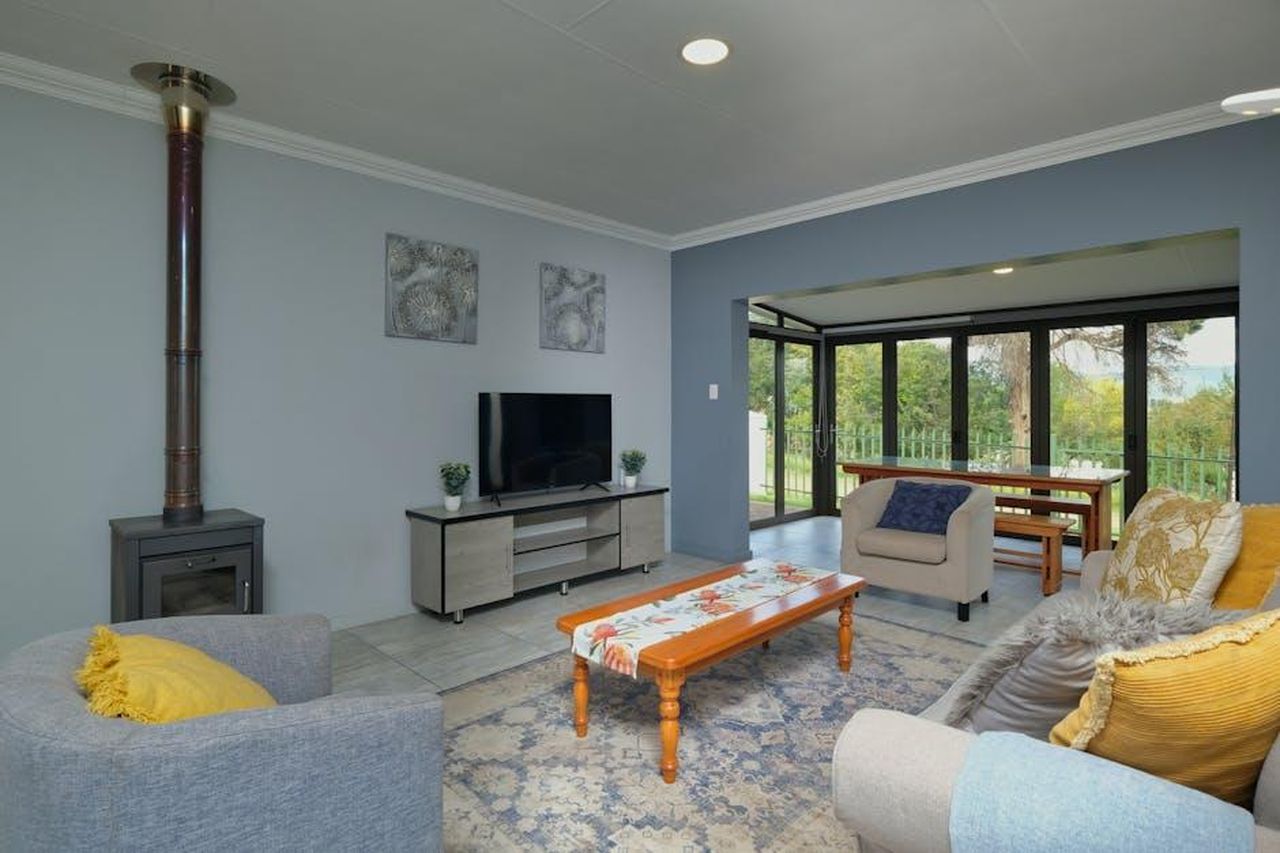 Source: Alexander F Ungerer - pexels - Spacious modern living room with cozy decor and dining area view in a home.