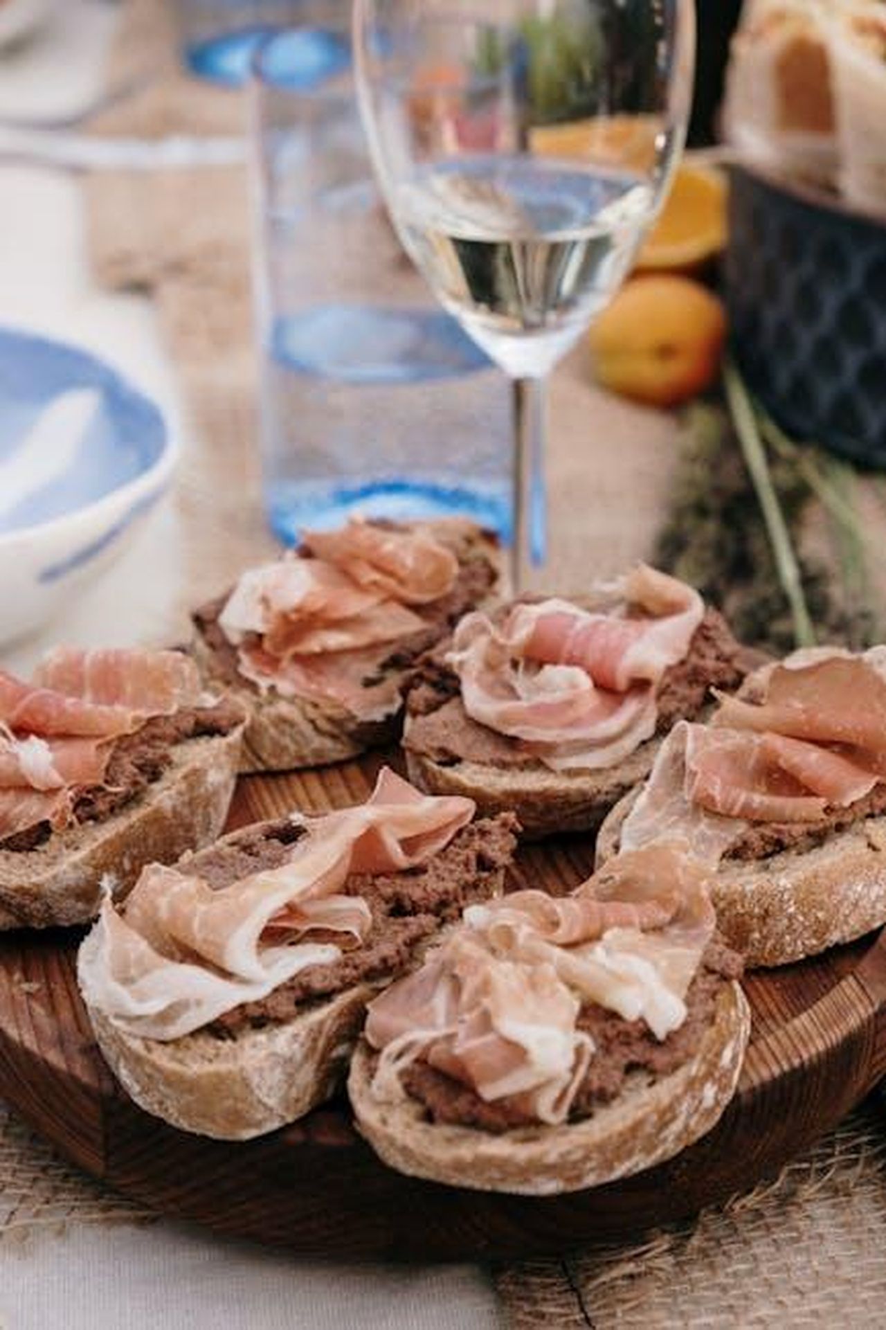 Source: cottonbro studio - pexels - A delicious spread of charcuterie on rustic bread paired with a glass of white wine.