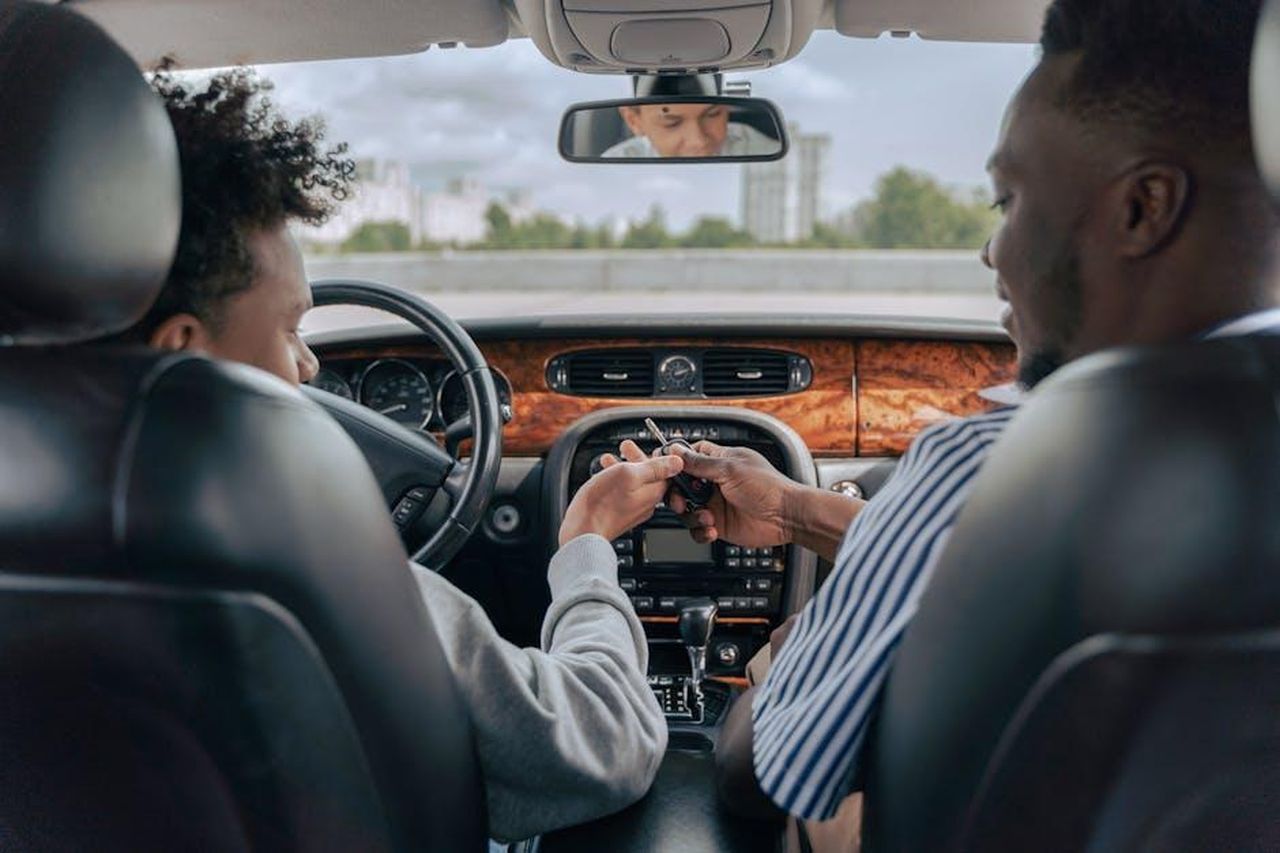 Source: Ron Lach - pexels - Father and teenage son inside car learning to drive, fostering bonding and guidance.