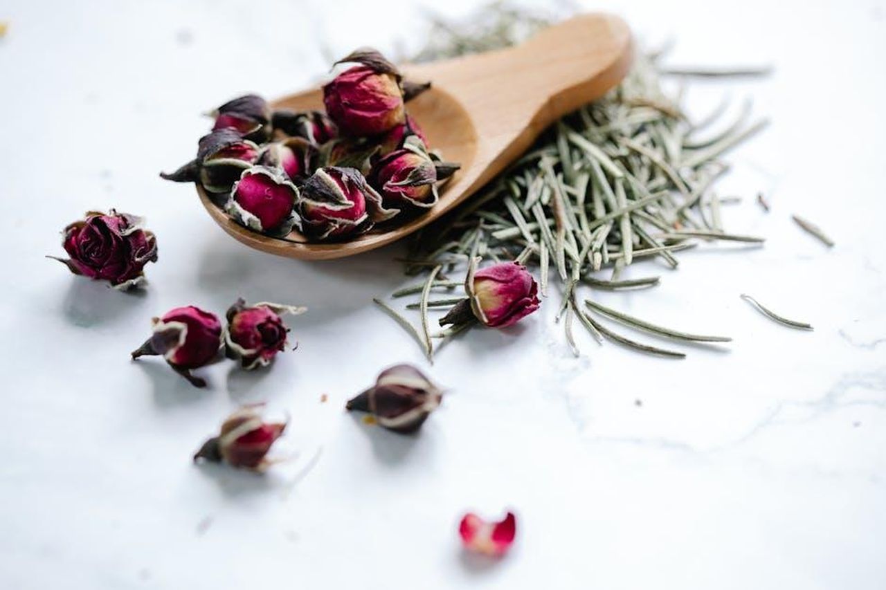Source: Anna Pou - pexels - Close-up of dried roses and rosemary on a white background, perfect for herbal tea blends.