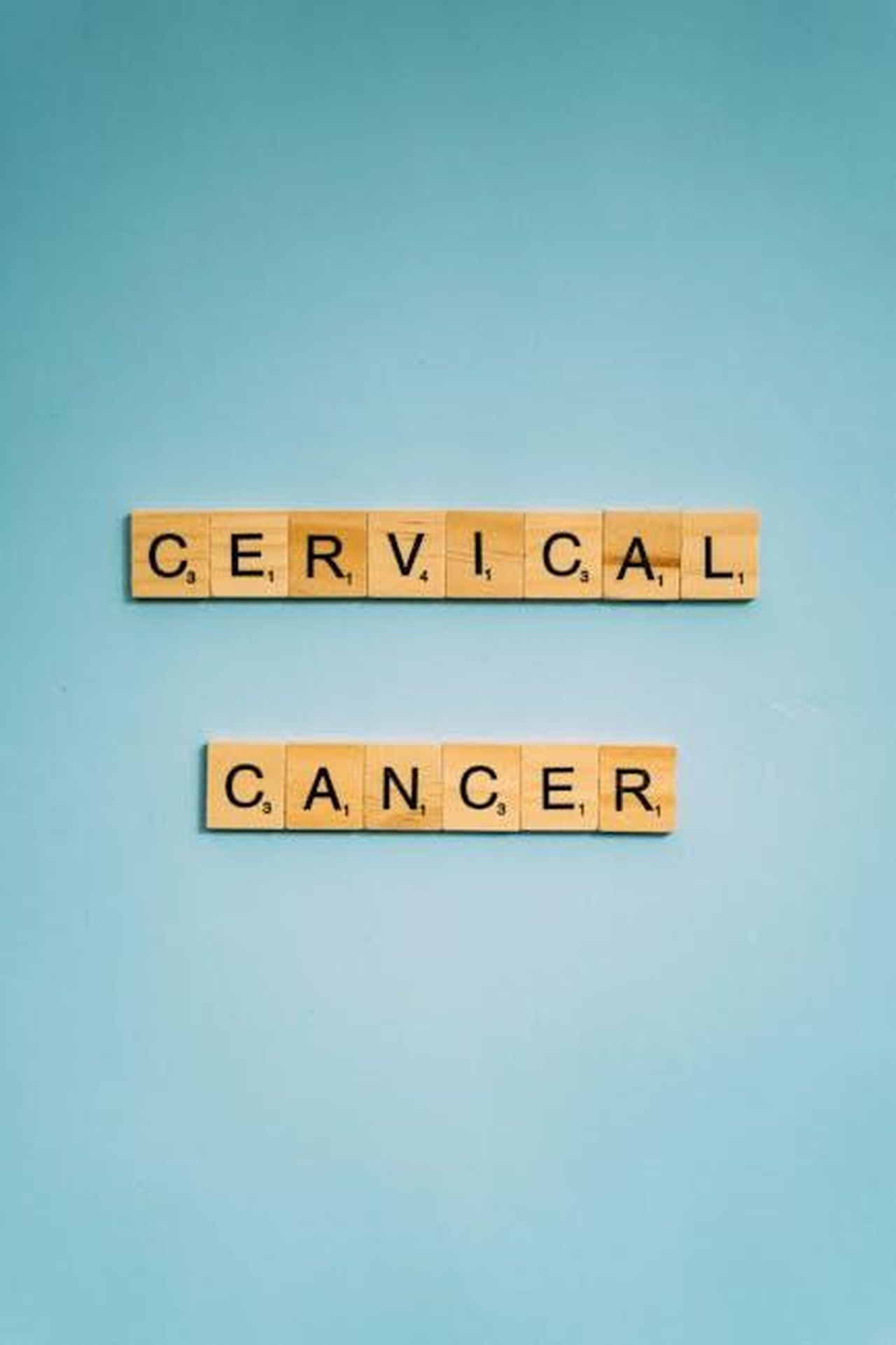 Source: Anna Tarazevich - pexels - Wooden tiles spell 'Cervical Cancer' on a light blue background, raising awareness.