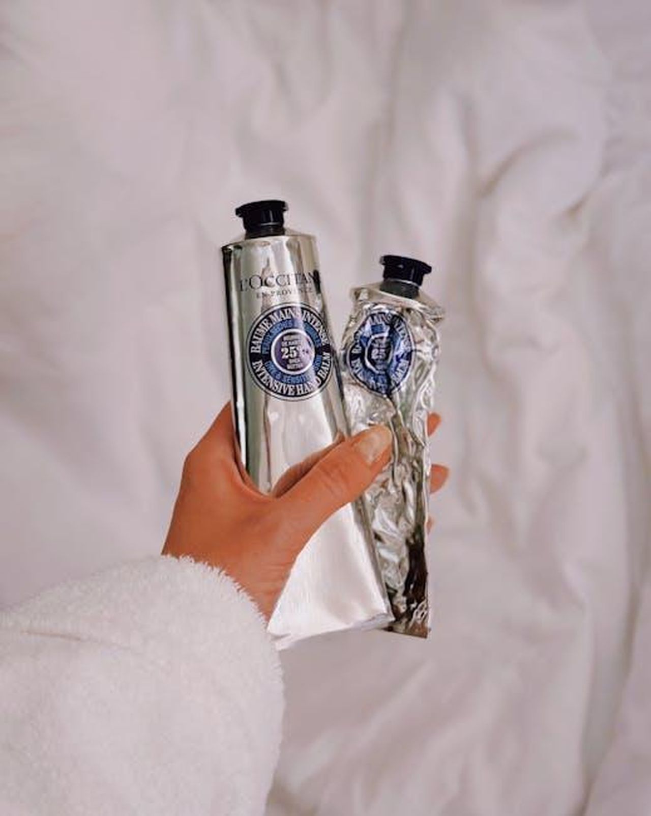 Source: Kateryna Hnidash - pexels - Close-up of hand holding L'Occitane creams, symbolizing luxury skincare routine.