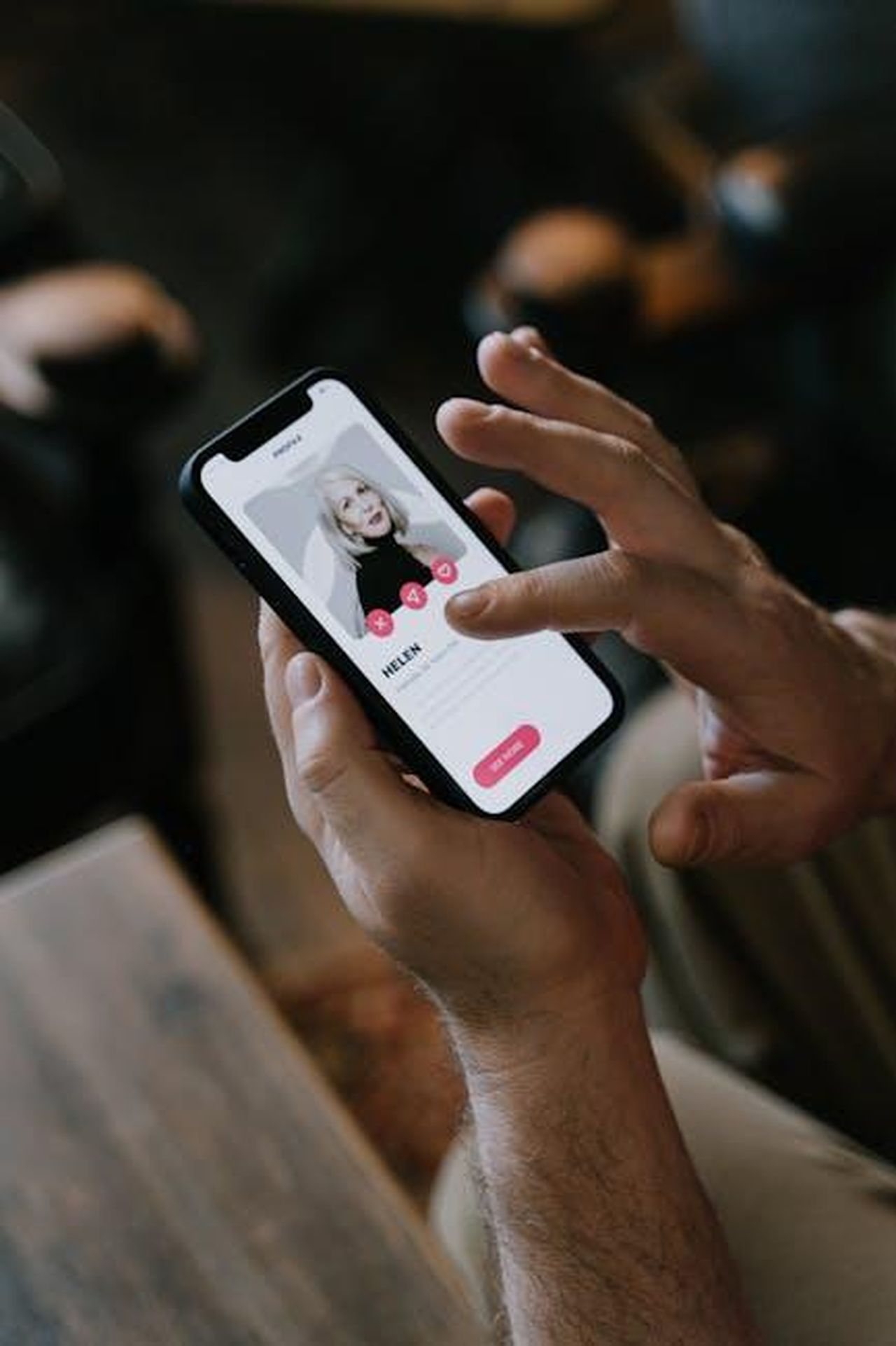 Source: cottonbro studio - pexels - Close-up of hands using a dating app on a smartphone indoors. Modern technology and online dating.
